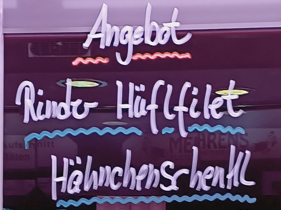 Fleischermeister Mehrens: Angebot der Woche handgeschrieben am Fenster des Verkaufswagens